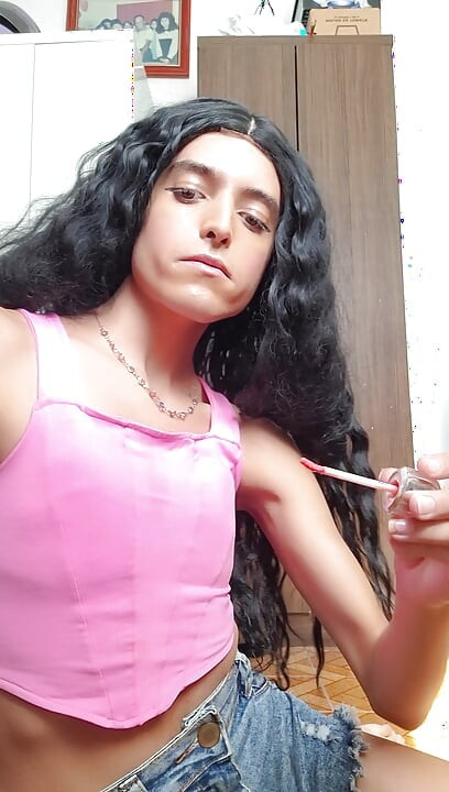 Cute shemale girl sucks the bottle of deodorant after applying lipstick
