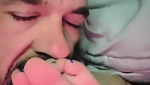 Sucking her toes while she watches a movie