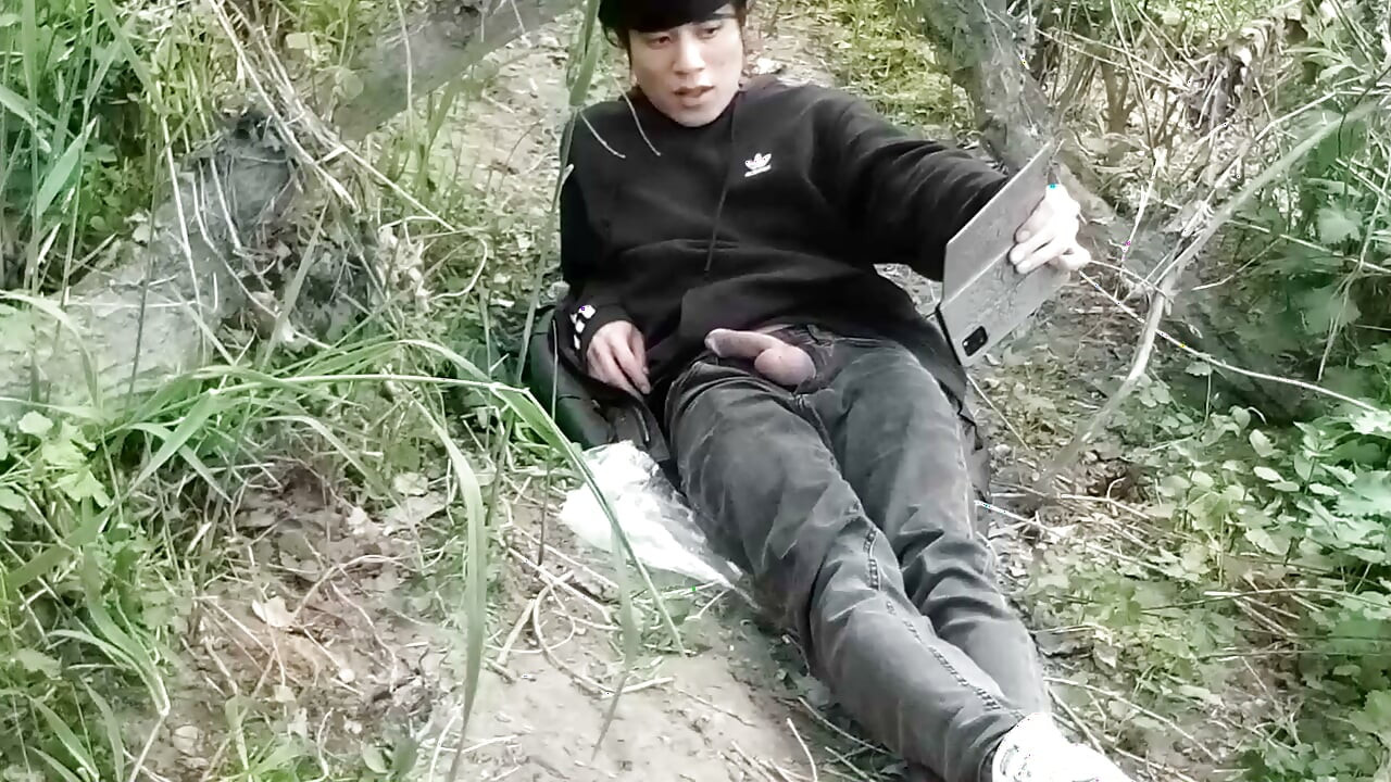 This gay twink sticks his cock through his fly to jerk off outside