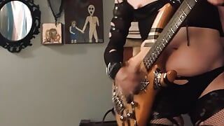 Une t-girl gothique sexy joue de la basse en lingerie