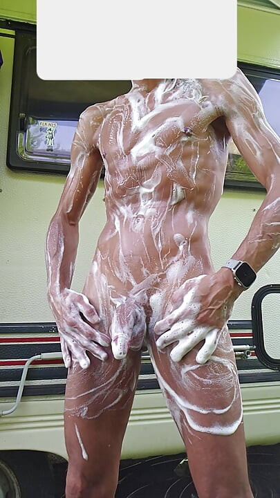Skinny boy showers outside in front of the camper while the neighbor next door works. Big cock wash and piss risky outdoor