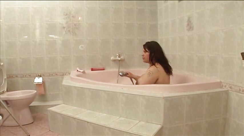 Pregnant women finger each other in a pink bathtub