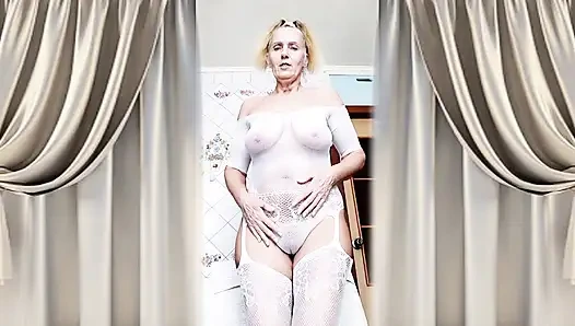 Hot housewife Lukerya flirts in an open transparent white jumpsuit in the kitchen.