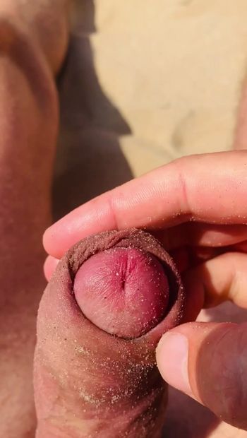 Masturbazione sulla spiaggia nudista in pubblico.