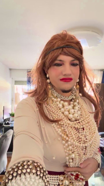 Crossdresser đi bộ xung quanh khu căn hộ trong đôi giày cao gót và ngọc trai và giày cao gót đáng yêu.