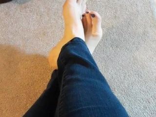 Mis pies descalzos recién pedicurados en jeans.