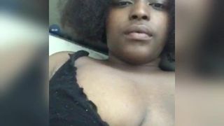 Dark skinned woman playing with her boobs