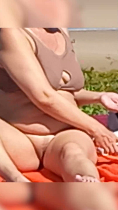 Nude beach Peeping at a lonely beach A woman undresses takes off her panties and bra, and sunbathes naked on a public beach.