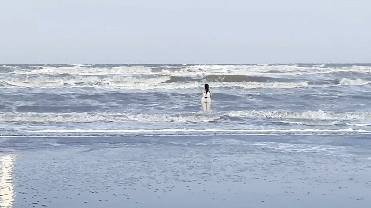 Mi vecina pierde su ropa en la playa.