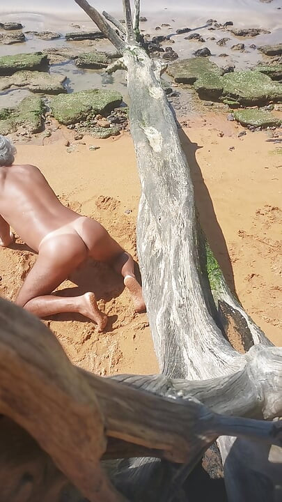 Ladysilva på stranden naken och visar upp sin solbrända sexiga rumpa