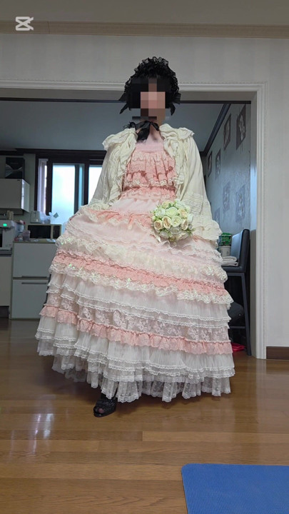 A man dressed as a woman dances in a dress.