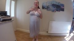 Une femme enceinte fait un strip-tease en robe de maternité