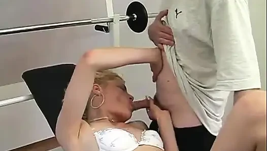 Ateşli olgun sarışın ağırlık makinesinde sert yarak ve ateşli bir yüze boşalma alıyor