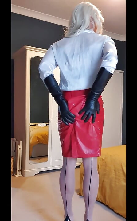 Dressed up feeling very sexy in her white satin blouse, shiny red skirt, opera leather gloves, nude seamed stockings and heeels.