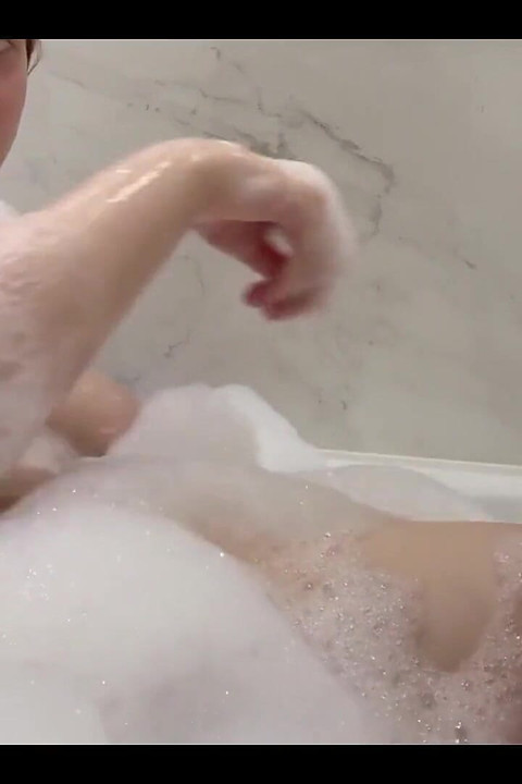 बहुत सारे बबल बाथ के साथ बाथरूम में फुहार और हस्तमैथुन करना