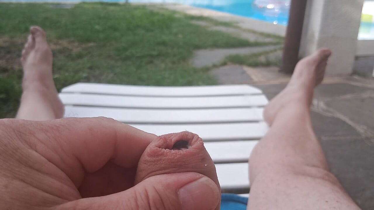 Masaje del pene junto a la piscina, con corrida