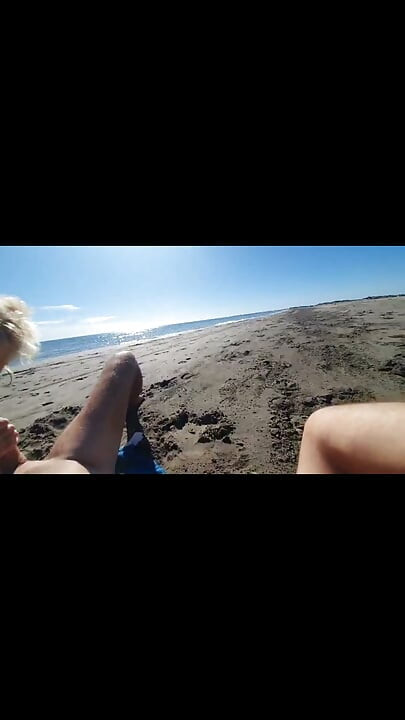 Une MILF chevauche une bite chargée sur une plage nudiste