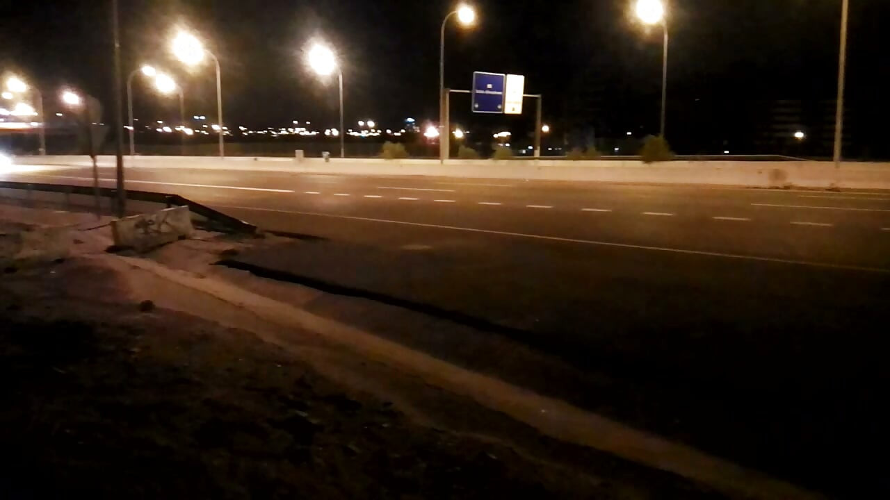 夜の車の前の道路で裸で