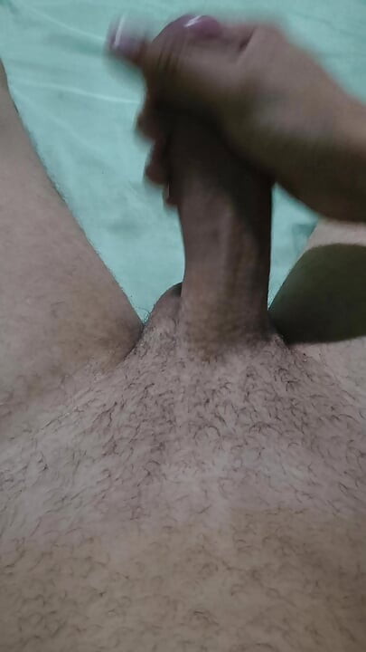 Naked man playing with big thick cock lying on bed
