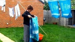 Sissy dona de casa pendura a roupa lavada