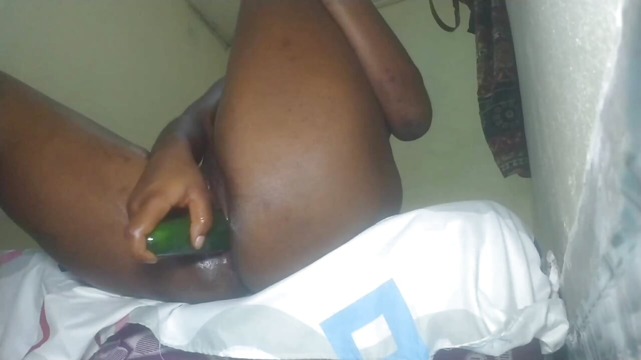 Black desi girl with an amazing body is putting a large cucumber into her pussy