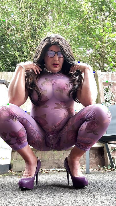 Seksi transvestit kellycd2022 u ljubičastom catsuitu i štiklama na otvorenom