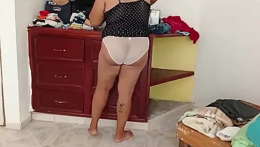 Tombul kız odayı topluyor ve kıyafetlerini katlıyor