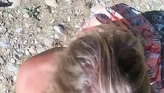 She sucks him at the water's edge