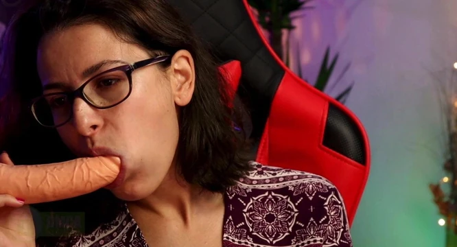 Woman with glasses sucking dildo sensually