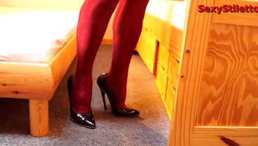 ハイヒールの黒のスティレットと赤いストッキングを履いて自宅で仕事