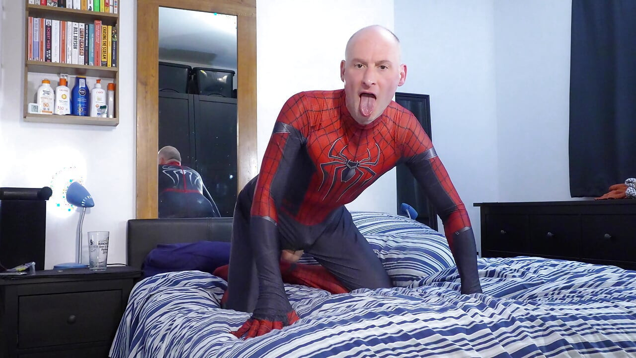 Jonathan in Spiderman-kostüm masturbiert seinen erigierten unbeschnittenen schwanz geil zum spielen