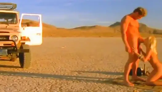 Sidik sırılsıklam sarışın bebek çöl altın duşu için diz çökerken