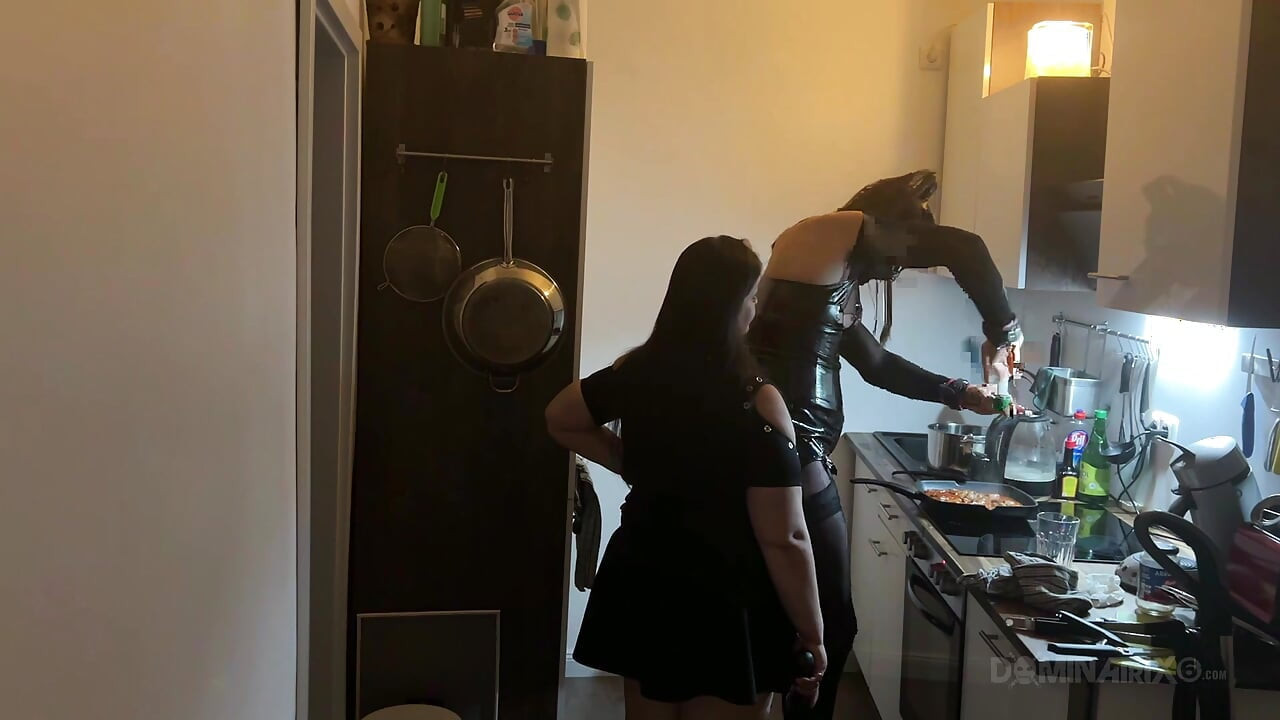 Milf dominante estira el culo del sumiso de látex en la cocina