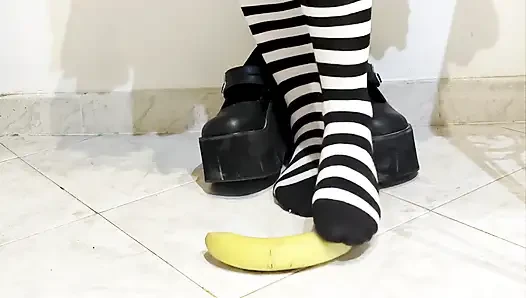 Goth crushing a banana under her shoes