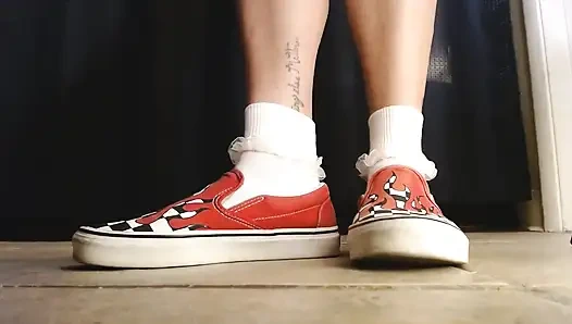 Cewek dengan kaus kaki putih dengan kaus kaki vans flame sneakers lagi asik main sepatu