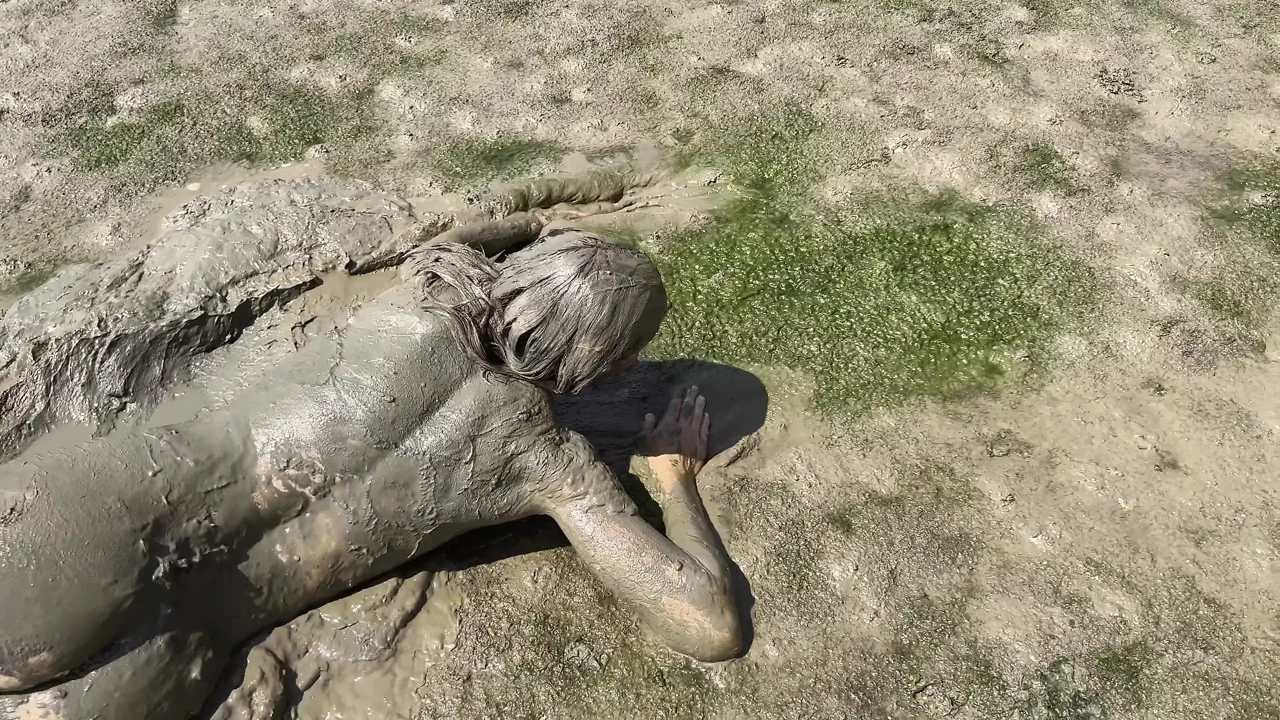 Estuary mud girl playing in the nude