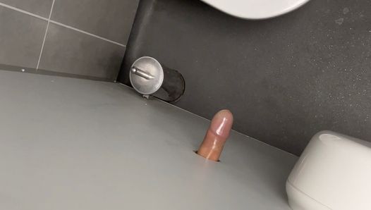 Je exhibe ma bite couverte de latex dans un gloryhole de toilettes publiques