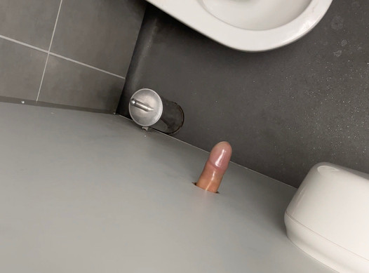 Je exhibe ma bite couverte de latex dans un gloryhole de toilettes publiques