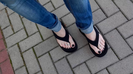 Un travesti tente avec ses pieds dans la rue