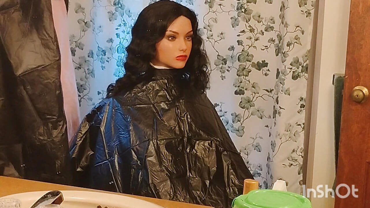 Emma the barberette shows off sexy vinyl shampoo capes