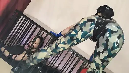 Latexoffizier fickt seine latex-gefangenen mit einem strap-on