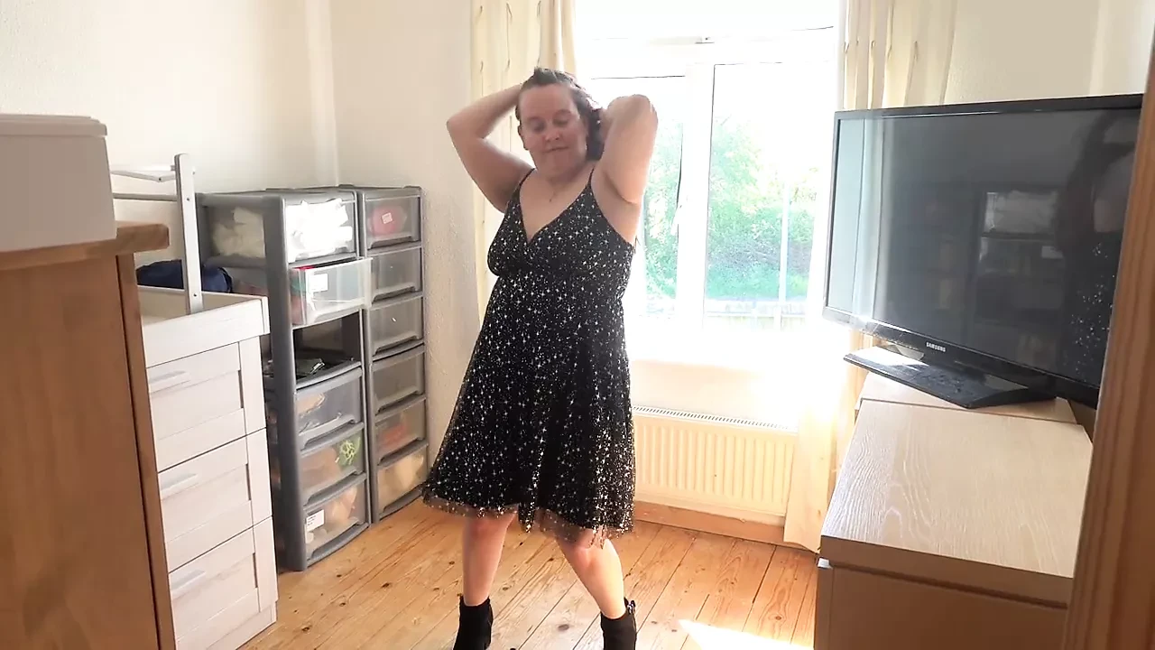 Elle exhibe sa robe de soirée à la fenêtre