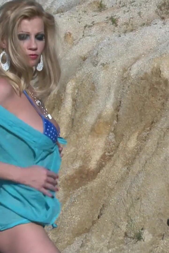 O blondă sexy își arată corpul fierbinte în aer liber