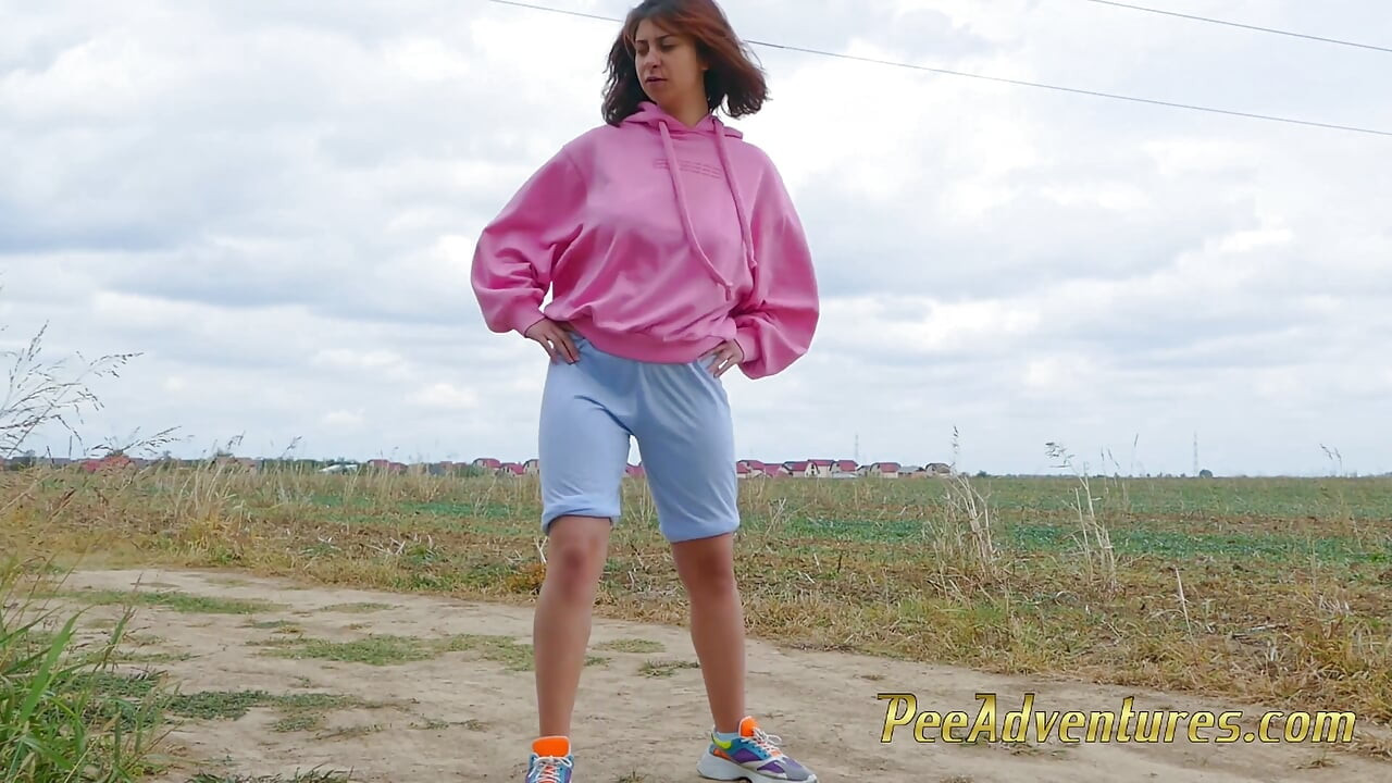 Wetting Her Jeans Outdoor - Desperate Hipster Girl Trying Hard to Pee - Pee Next to the Wheel of the Car