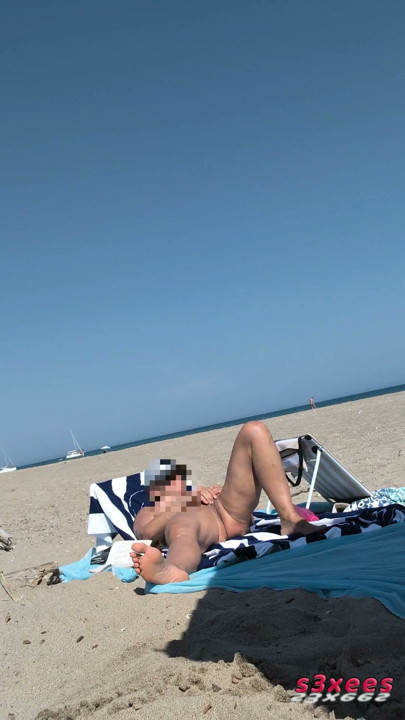 She masturbates her on the naturist beach in public with a voyeur who passes by | Clip 1