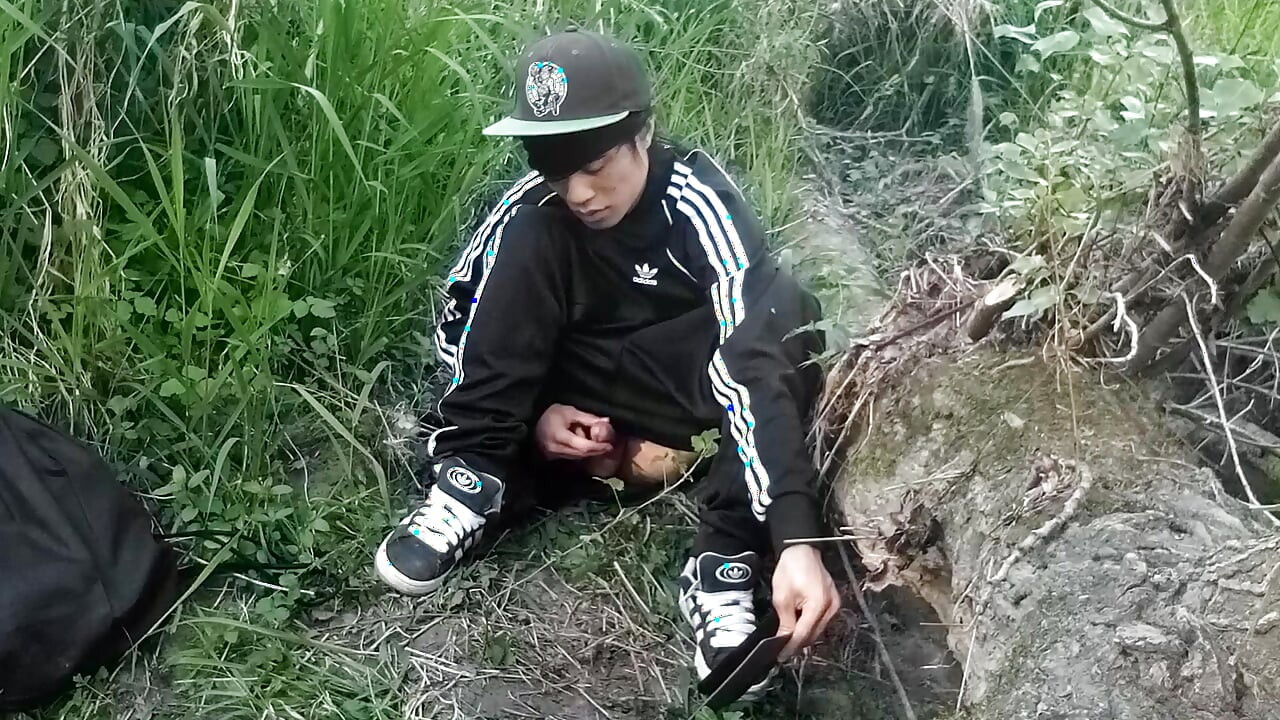 Cute Asian gay twink in a black-and-white adidas tracksuit and Campus sneakers masturbates and cums outdoors