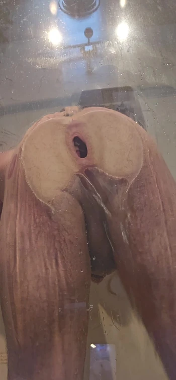 Trou du cul qui presse contre le verre de la douche