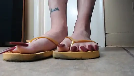 Zehennägel hängen an gelben flip-flops