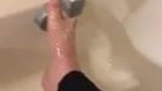 Alexis Black rubs her feet in the bath with leggings