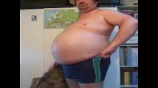 Przerażający otyły mężczyzna pokazuje swój tłuszcz